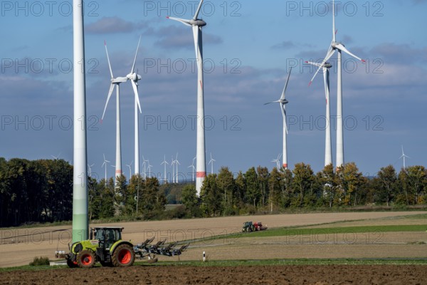 Farmer working in the fields, with a tractor, wind farm above the village of Lichtenau,