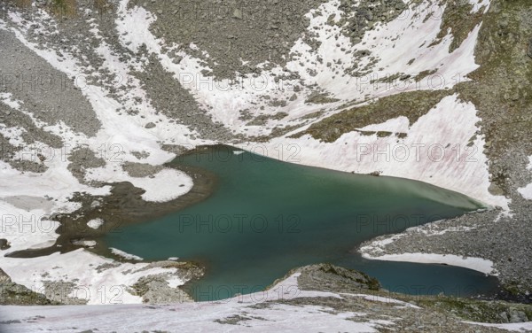 Mountain landscape with snow and blue lake Friesenbergsee, Berliner Höhenweg, Zillertal Alps,