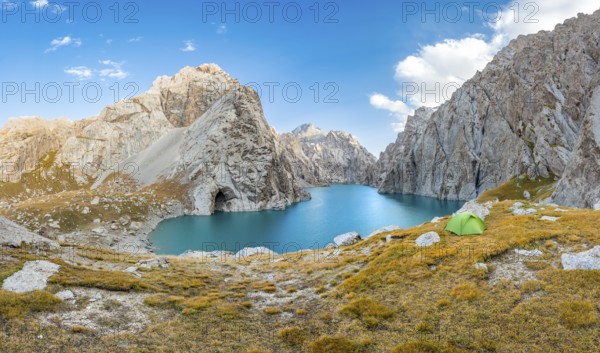 Green tent at the turquoise mountain lake Kol Suu with rocky steep mountains, Kol Suu Lake, Sary