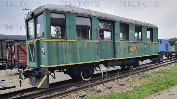 Green railway wagon with yellow details on a rail network, historical railcar, railway museum, Elk,