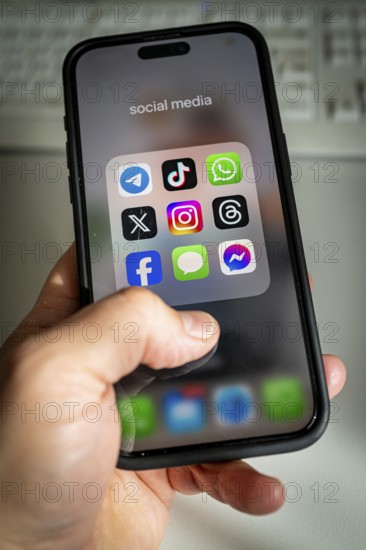 A smartphone shows various social media apps, threads, tik tok, Telegram & co on the screen