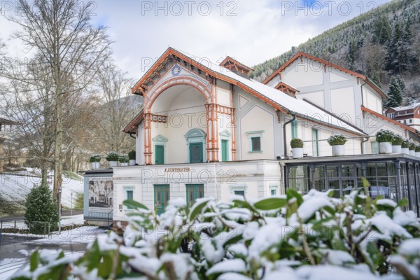 Historic theatre in a snow-covered winter landscape with wooded mountains in the background, Royal