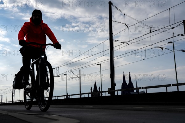 Cycling in the city, cyclist on the Deutzer Bridge in Cologne, Cologne Cathedral, cycle path, North