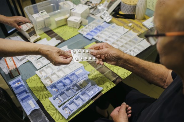 Symbolic photo on the subject of taking medication in old age. Two senior citizens sort various