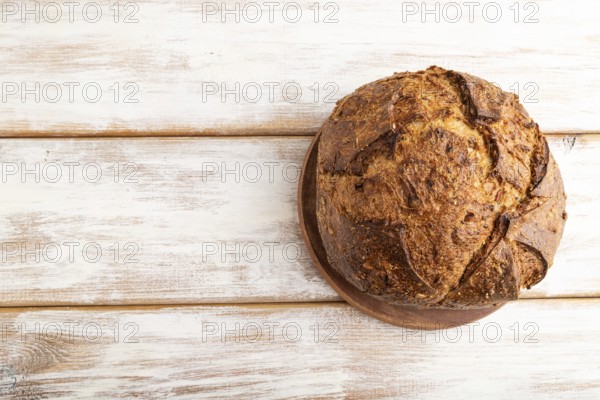 Fresh homemade golden grain bread with wheat and rye on white wooden background. top view, flat