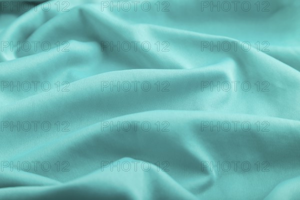 Fragment of silk blue tissue. Side view, natural textile background and texture. wave concept,