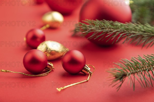 Christmas or New Year composition. Decorations, red balls, fir and spruce branches, on a red paper