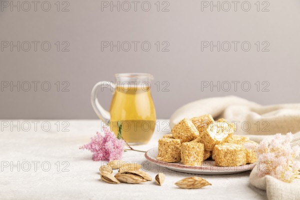 Traditional turkish delight (rahat lokum) with glass of green tea on a gray concrete background and