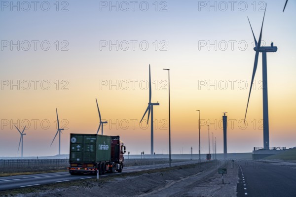 Lorry on the road from Euromax Terminal Rotterdam, ENECO wind farm on the dike around the port of
