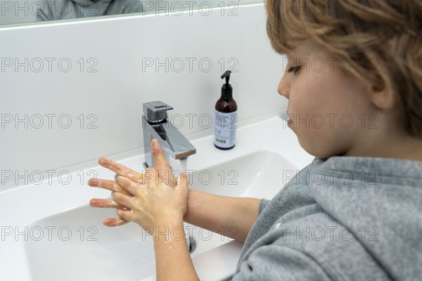 Domestic hygiene, washing hands with liquid soap, boy 9 years old