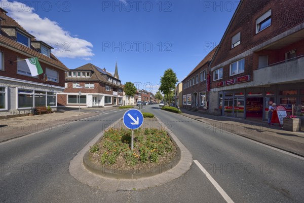 Traffic island with traffic sign for passing on the right on Weseler Strasse in Buldern, Dülmen,