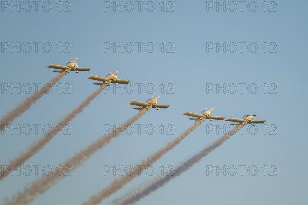 Stunt aerobatic planes performing stunts in blue sky with smoke trail. Concept of teamwork,