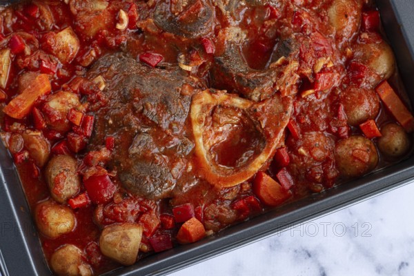 Ossobuco stew with vegetables, knuckle on the bone with new potatoes, in tomato sauce, homemade,