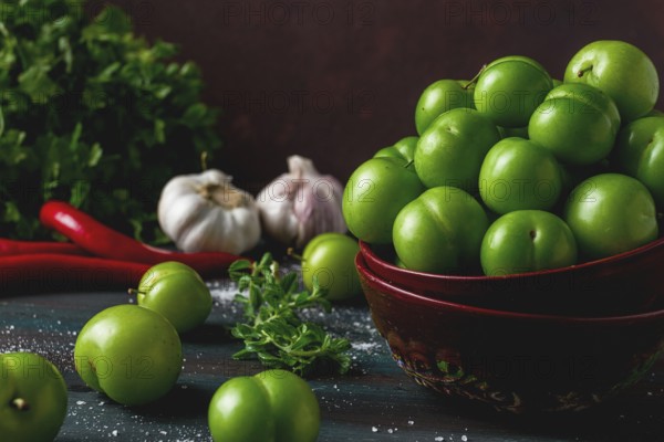 Tkemali, green cherry plum, with ingredients for sauce, cilantro, mint, hot pepper, garlic, on a
