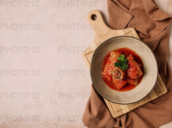 Stuffed cabbage rolls, with minced meat, in tomato sauce, on a beige background, food and drink,