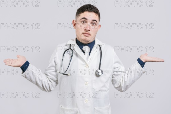 Puzzled doctor with open hands. Doubtful young doctor with open hands isolated. Insecure doctor