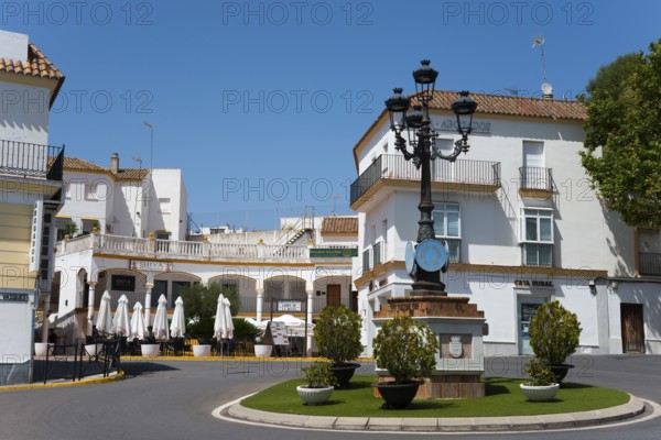Inviting square with cafés and typical white houses, crowned by a decorative street lamp, Arcos de