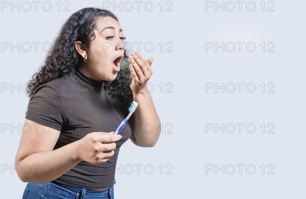 Young woman holding brush with bad breath isolated. Person with brush and bad breath isolated,