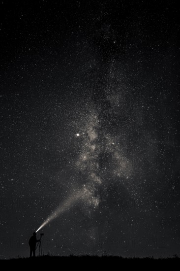 Photographer with tripod and headlamp light in a meadow with starry sky, Mindelheim, Unterallgäu,
