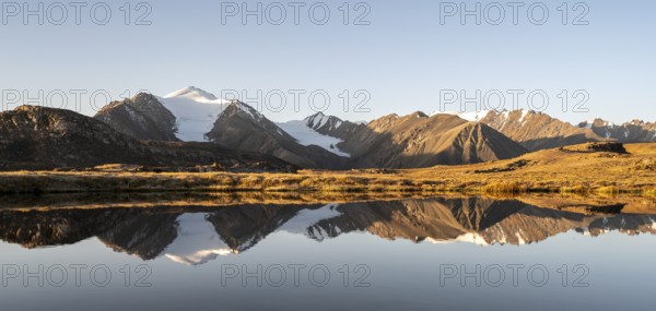 Glaciated mountain peaks reflected in a mountain lake at sunset, Arabel Lake at Arabel Pass, Issyk