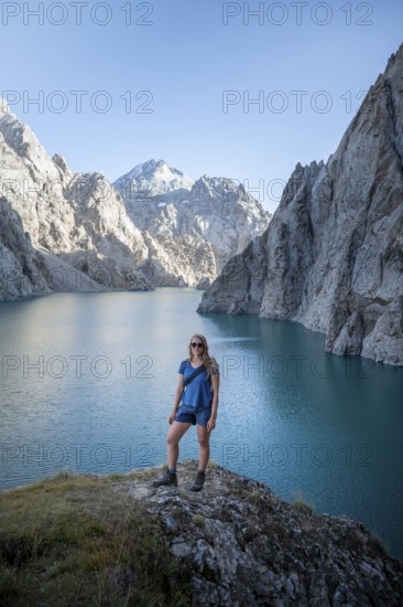 Hiker in front of mountain lake Kol Suu, Sary Beles Mountains, Naryn Province, Kyrgyzstan, Asia