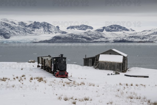 Historic mine railway in front of the wintery, snow-covered Kongsfjorden, Ny-Ålesund, Spitsbergen