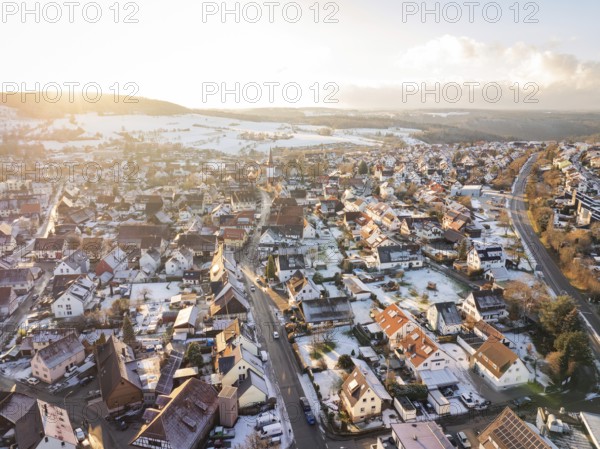 Village street in winter atmosphere, surrounded by snow-covered houses and fields, Calw- Stammheim,