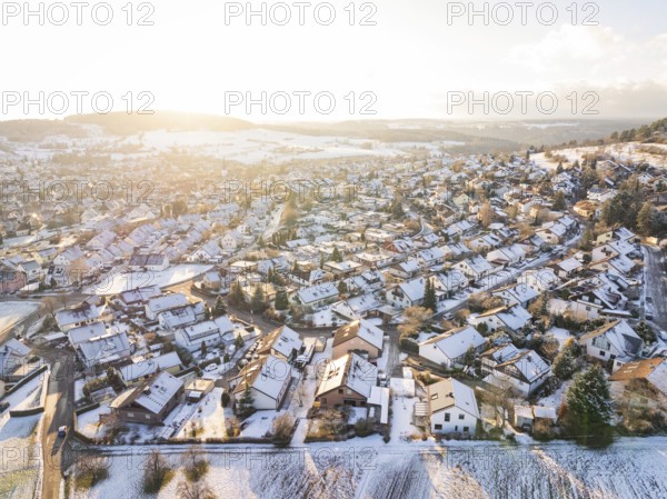 Snowy village in hilly landscape with winter sunlight over the fields, Calw- Stammheim, Black