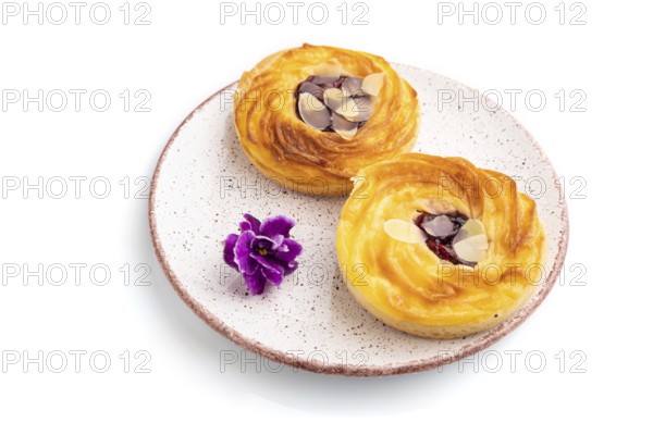 Small cheesecakes with jam and almonds isolated on white background. Side view, close up