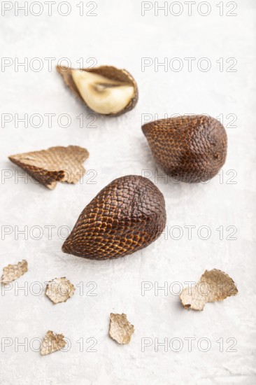 Salak or snake fruit on gray concrete background. Side view, close up, selective focus. Tropical,