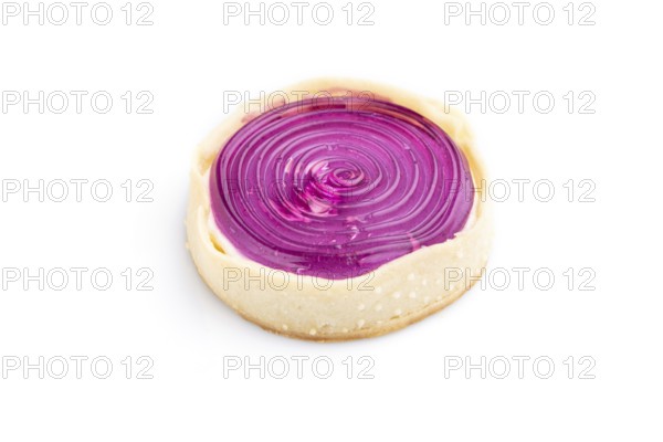 Single sweet tartlet with jelly and milk cream isolated on white background. Side view, close up