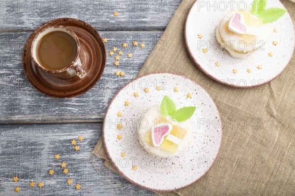 Decorated cake with milk and coconut cream with cup of coffee on a gray wooden background and linen