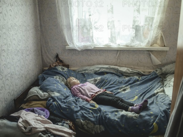 Angelina, 9 years old, on her bed. The village of Borshchivka was under Russian occupation. She has