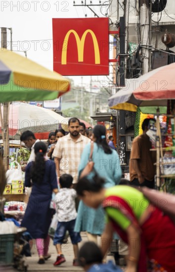 People walks by a McDonald's sign on October 26, 2024 in Guwahati, India. McDonald's recent food