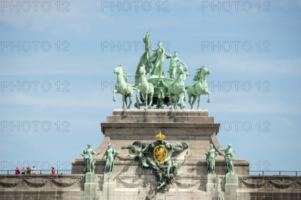 Monumental sculpture group on a triumphal arch in front of a blue sky, quadriga, close-up, people,