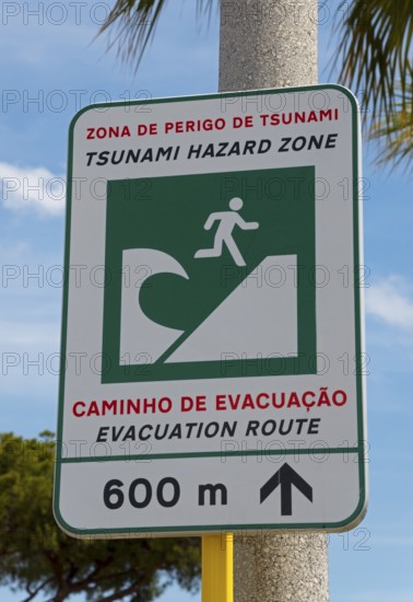 Warning sign for a tsunami danger zone near the beach with evacuation notice, Vilamoura, Faro,