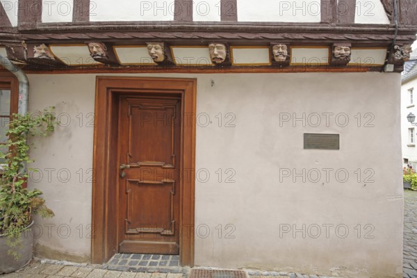 Half-timbered house with seven envious heads and wood carvings, envious head, grimace, faces, front