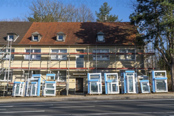 Energy-efficient refurbishment of residential buildings, older apartment block is scaffolded, gets