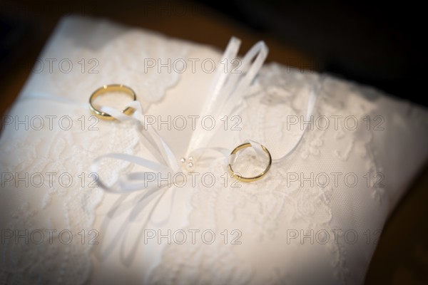 Wedding rings on an ornate white cushion