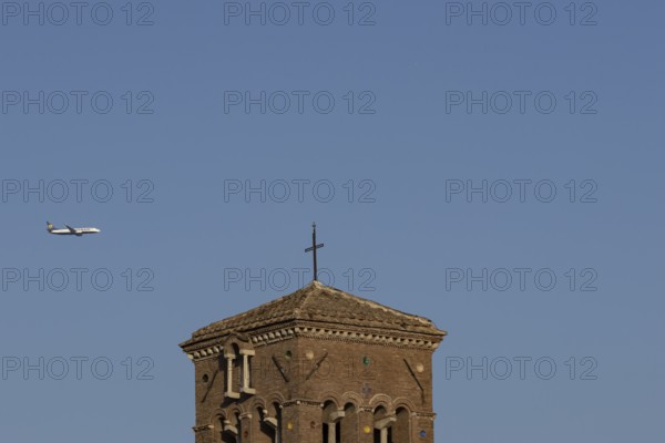 Boeing 737 jet passenger aircraft of Ryanair flying in a blue sky over an ancient city building,