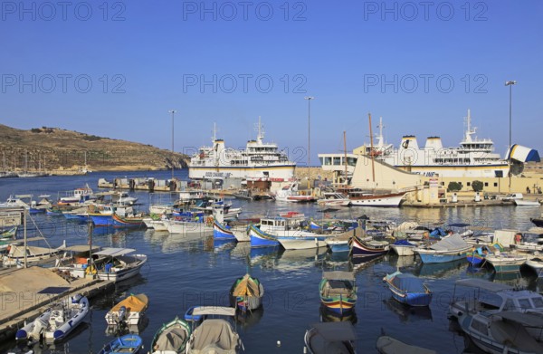 Colourful boats in harbour ferry port terminal at Mgarr, island of Gozo, Malta, Europe