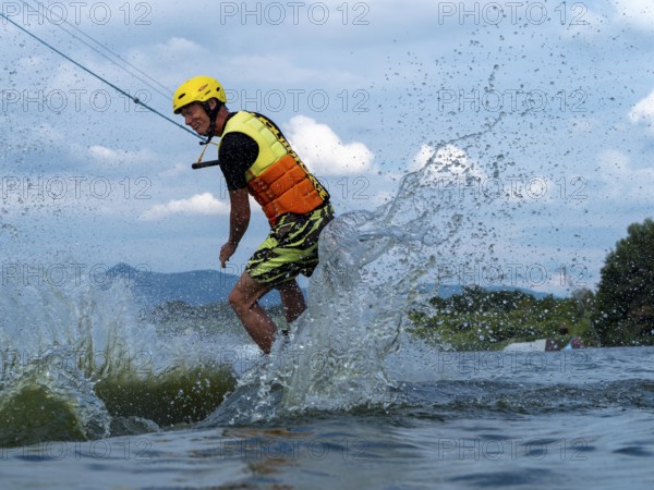 Man jumping with wakeboard, water sports, water skiing and wakepark