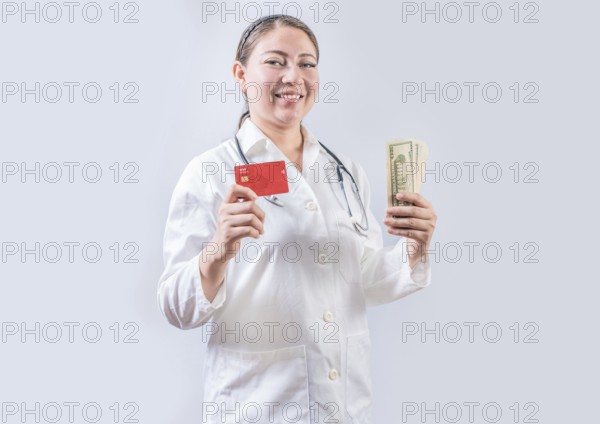 Beautiful and smiling female doctor holding money and credit cards. Happy female doctor holding