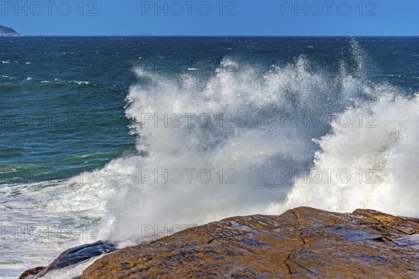 Sea water splashing after a wave crashes hard against the rocks on Ipanema beach in Rio de Janeiro,