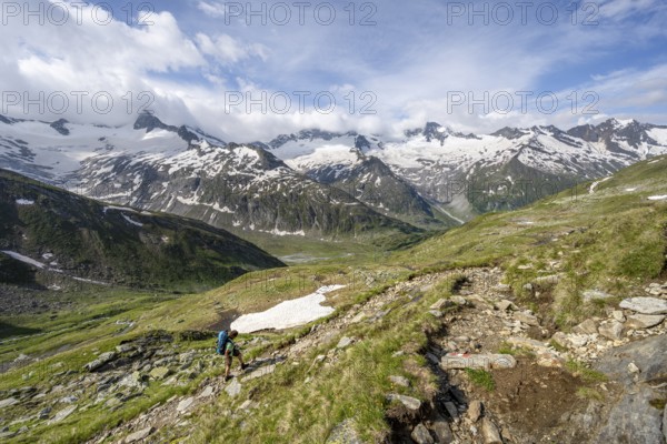 Mountaineer on hiking trail in picturesque mountain landscape, mountain peak with snow and glacier