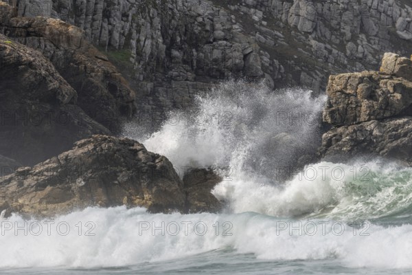 Large waves of the Atlantic Ocean crash against the rocks of a cliff. Camaret sur mer, Crozon,