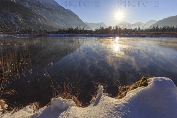 Mountains reflected in lake, evening light, sunbeams, snow, winter, seven springs, behind