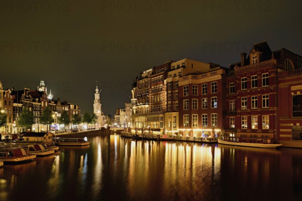 Historic buildings and mint tower illuminated at night, Singelgracht, Amsterdam, North Holland,