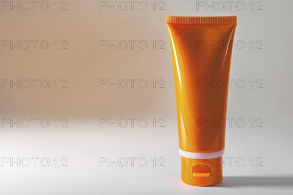 Orange sunscreen tube on white studio background with copy space. KI generiert, generiert, AI
