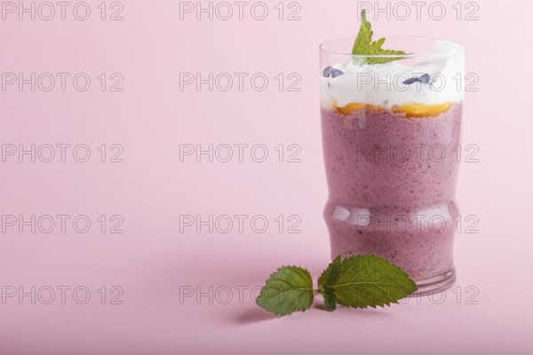 Smoothie with honeysuckle, linen and chia in a glass on pink pastel background. side view, close